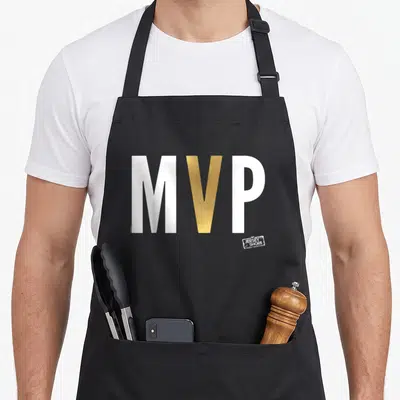 Mvp shore apron - Bold white and gold MVP text with small Jersey Shore Family Vacation logo stamp — shown on a black cotton canvas apron against a white background