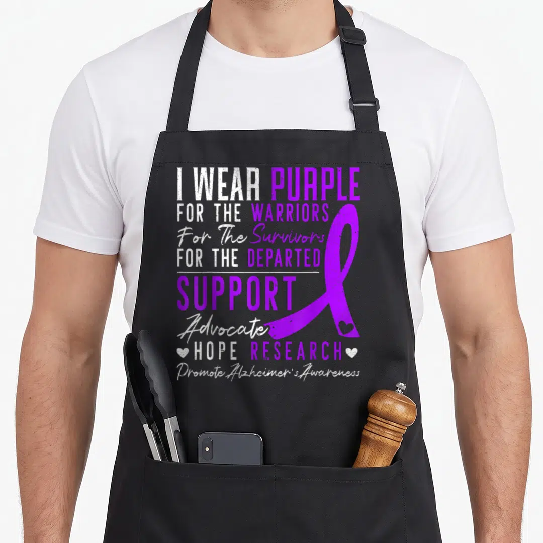 Awareness alzheimer's aprons - I WEAR PURPLE text with purple ribbon and two small hearts flanking hope research line — shown on a black cotton canvas apron against a white background