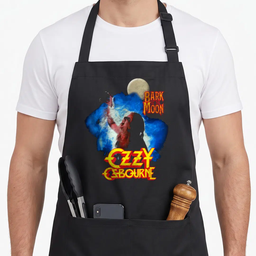 Bark ozzy osbourne apron - Werewolf over blue splash with Bark At The Moon and Ozzy Osbourne text — shown on a black cotton canvas apron against a white background