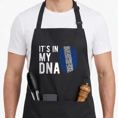 Dna honduran boy apron - IT'S IN MY DNA text next to a blue and white fingerprint pattern — shown on a black cotton canvas apron against a white background