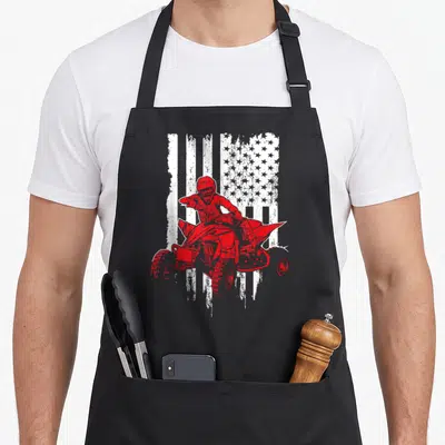 Terrain american flag apron - Red ATV rider silhouette on distressed white USA flag pattern — shown on a black cotton canvas apron against a white background