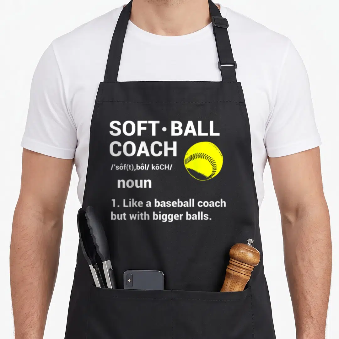 Ball coach baseball apron - Dictionary style text reading SOFT•BALL COACH next to a yellow softball illustration — shown on a black cotton canvas apron against a white background
