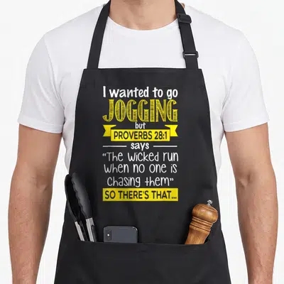 Wanted jogging christian apron - White and yellow typography reading I wanted to go jogging but Proverbs 28:1 says so — shown on a black cotton canvas apron against a white background