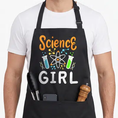 Biologist teacher apron - Science GIRL text with atom, test tubes, and DNA in orange, blue, green, and yellow — shown on a black cotton canvas apron against a white background