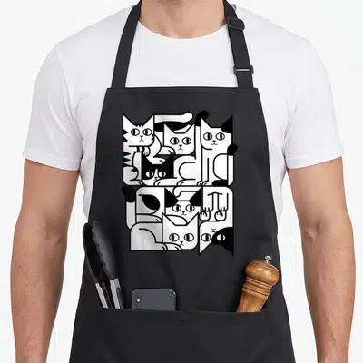 Feline kitten apron - Seven interlocking black and white line-art cats forming a geometric rectangle — shown on a black cotton canvas apron against a white background