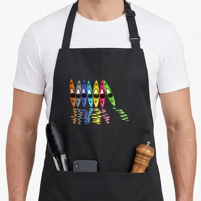 Kayak colorful aprons - Seven colorful kayaks in orange grey blue yellow pink and green with wavy reflections — shown on a black cotton canvas apron against a white background