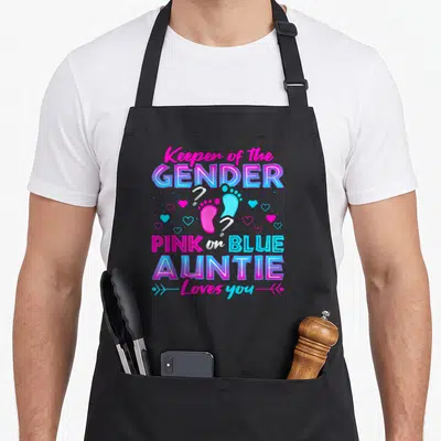 Keeper gender apron or apron - Stacked pink and blue text with two baby footprints and hearts on black bib — shown on a black cotton canvas apron against a white background