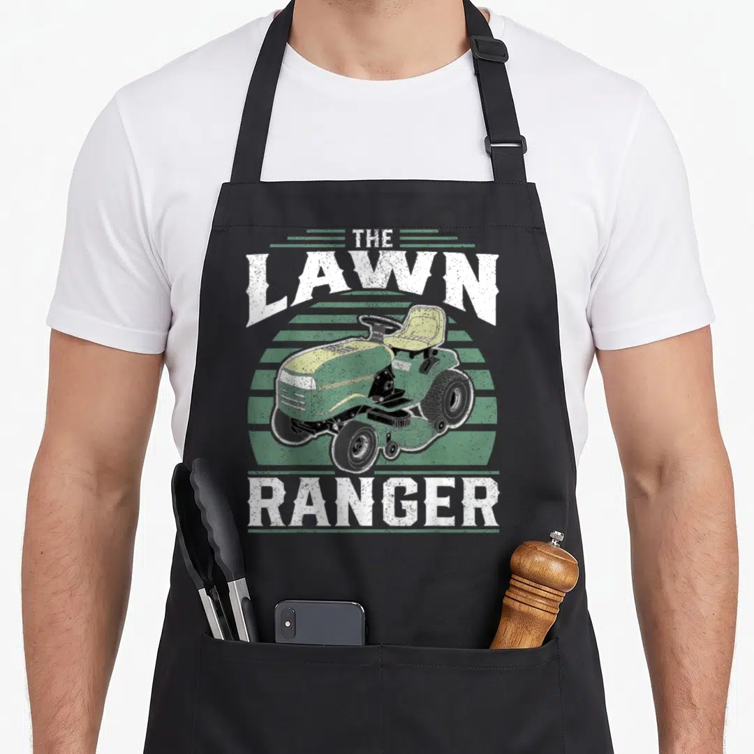 Riding rangers apron - Distressed graphic of green riding mower with THE LAWN RANGER text over green stripes — shown on a black cotton canvas apron against a white background