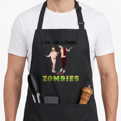 Zomby zombie apron - Photo of girl in pink and zombie boy in maroon with A Girl and a Zombie text — shown on a black cotton canvas apron against a white background