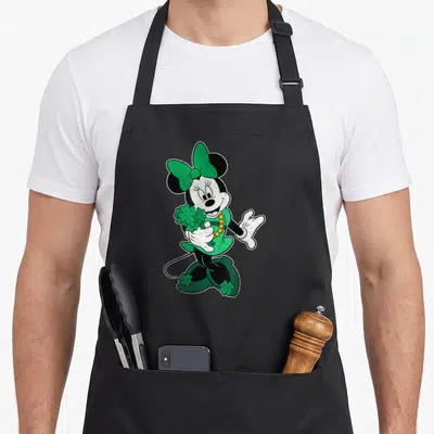 Cute leaf st patrick day aprons - Minnie Mouse standing holding clovers in green, black, white cartoon — shown on a black cotton canvas apron against a white background