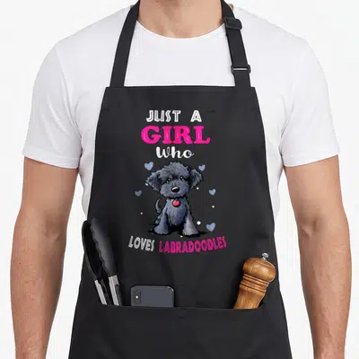 Vintage labradoodle dog apron - Cartoon grey labradoodle with pink text and blue hearts on grey background — shown on a black cotton canvas apron against a white background