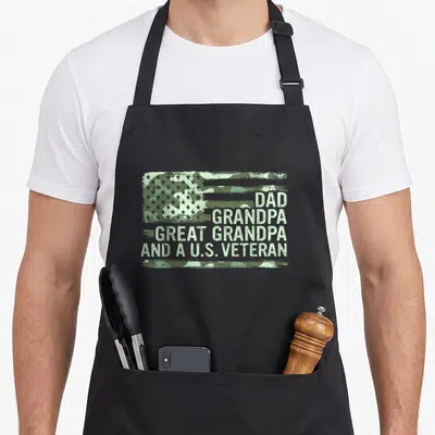 Cool grandpa father day apron - Distressed camo flag with stacked text Dad Grandpa Great Grandpa and U.S. Veteran — shown on a black cotton canvas apron against a white background