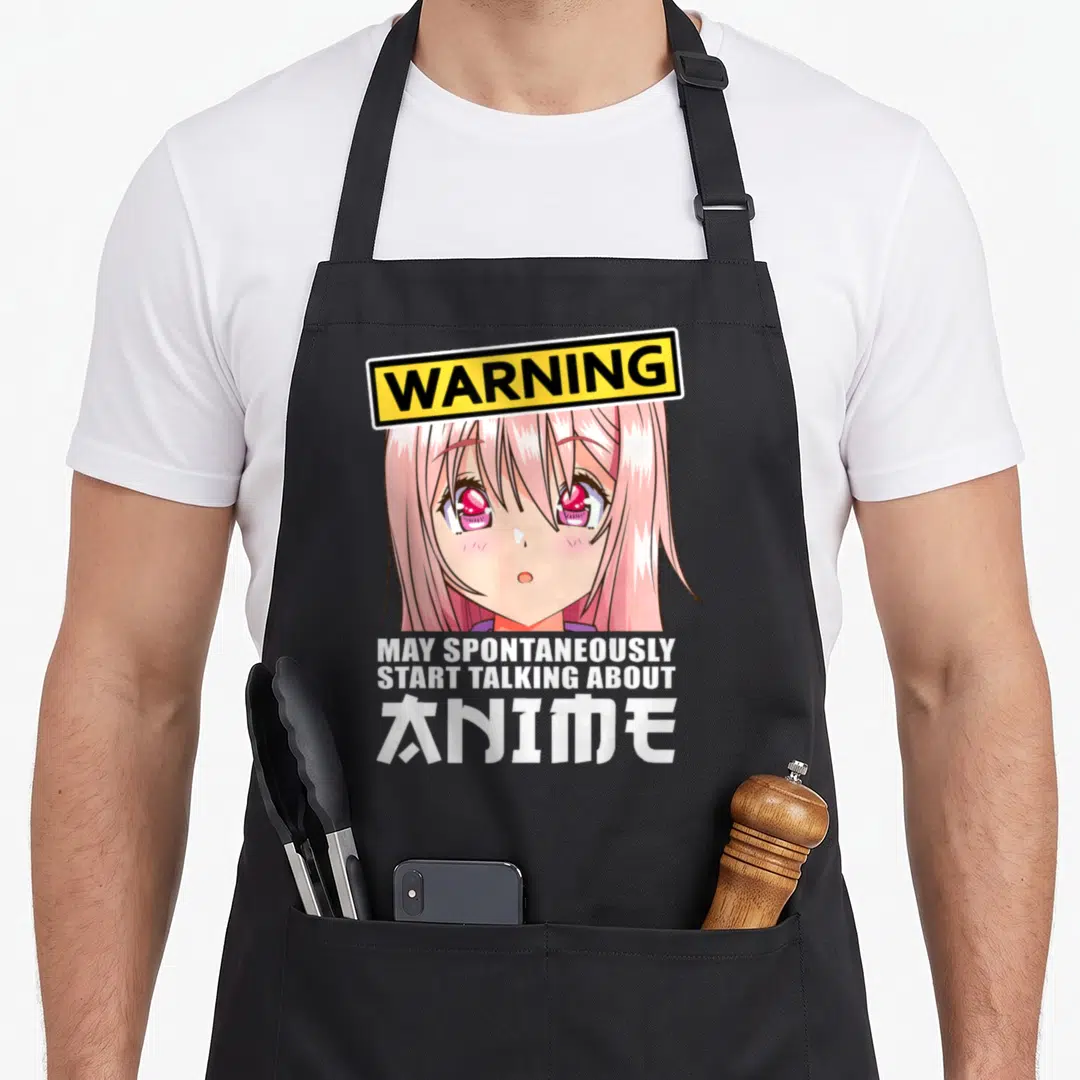 Clothe anime apron - Pink anime girl face under yellow WARNING sign with white stacked text — shown on a black cotton canvas apron against a white background