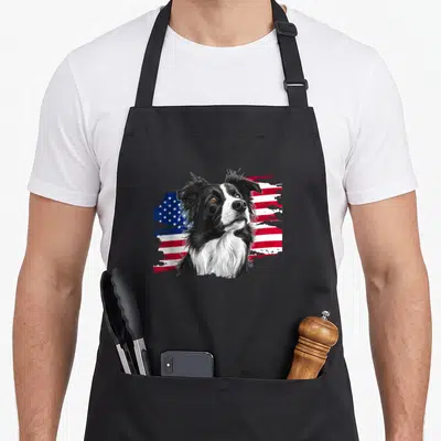 Patriotic border collie apron - Realistic black and white border collie head over distressed red white and blue flag — shown on a black cotton canvas apron against a white background