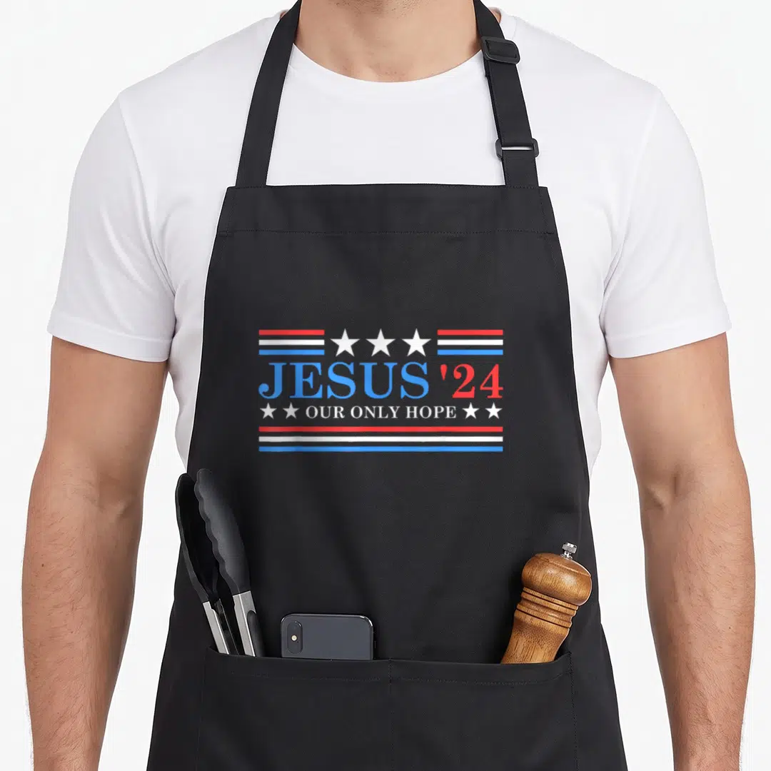 Jesus political aprons - JESUS '24 OUR ONLY HOPE text with red white blue stripes and stars — shown on a black cotton canvas apron against a white background