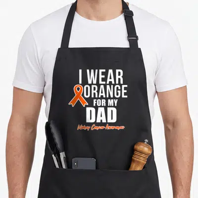 Cancer kidney disease awareness apron - Orange ribbon next to white text I WEAR ORANGE FOR MY DAD Kidney Cancer — shown on a black cotton canvas apron against a white background