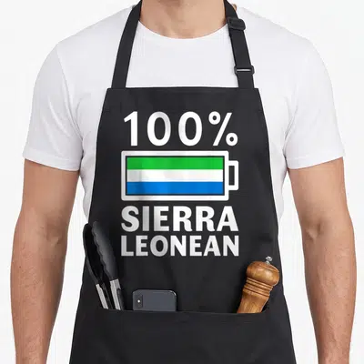 Sierra battery apron - Battery icon filled with green white and blue stripes between 100% Sierra Leonean text — shown on a black cotton canvas apron against a white background
