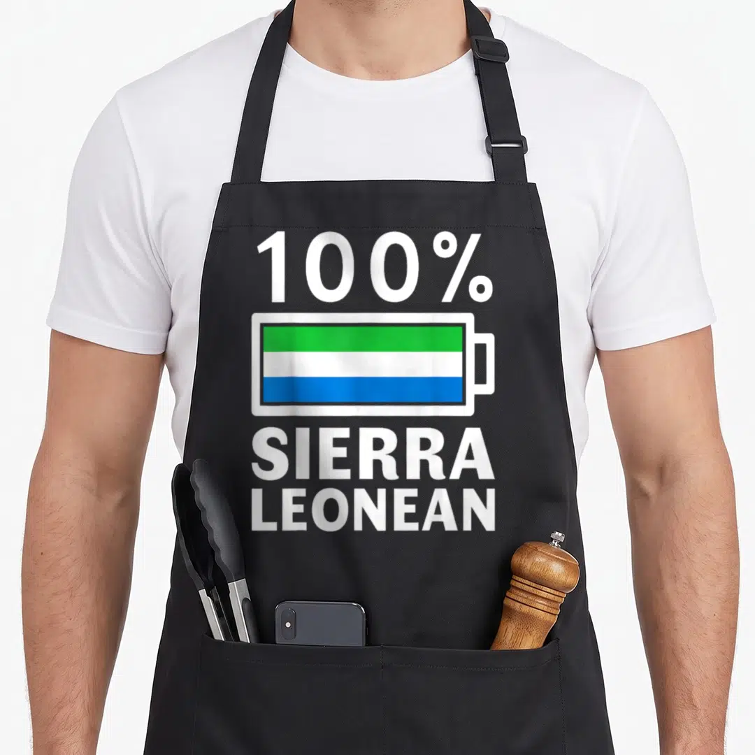 Sierra battery apron - Battery icon filled with green white and blue stripes between 100% Sierra Leonean text — shown on a black cotton canvas apron against a white background