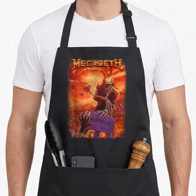 Megadeth heavy metal apron - Skeleton holding purple FOR SALE tombstone amidst orange explosion with MEGADETH text — shown on a black cotton canvas apron against a white background