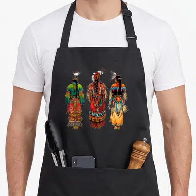 Headdress native american apron - Three cartoon Native American men seen from behind in red green orange blue — shown on a black cotton canvas apron against a white background