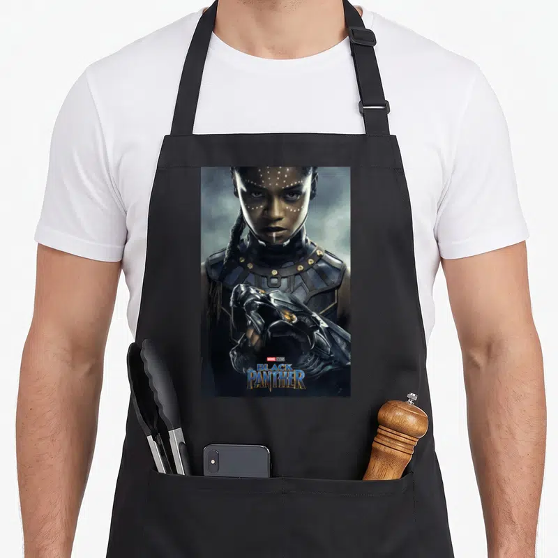 Poster panther apron - Photo of woman in black blue and gold armor with Marvel Studios Black Panther text overlay — shown on a black cotton canvas apron against a white background