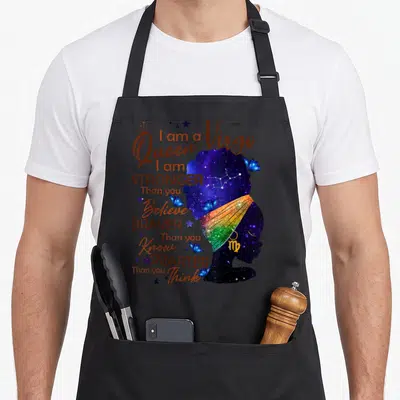 Stronger birthday apron - Galaxy silhouette woman with rainbow headwrap and text I am a Virgo Queen stronger than you — shown on a black cotton canvas apron against a white background