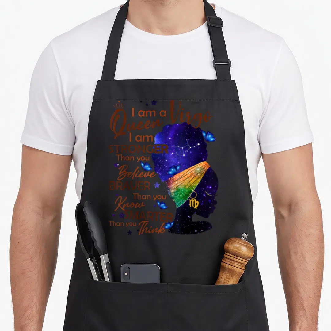 Stronger birthday apron - Galaxy silhouette woman with rainbow headwrap and text I am a Virgo Queen stronger than you — shown on a black cotton canvas apron against a white background