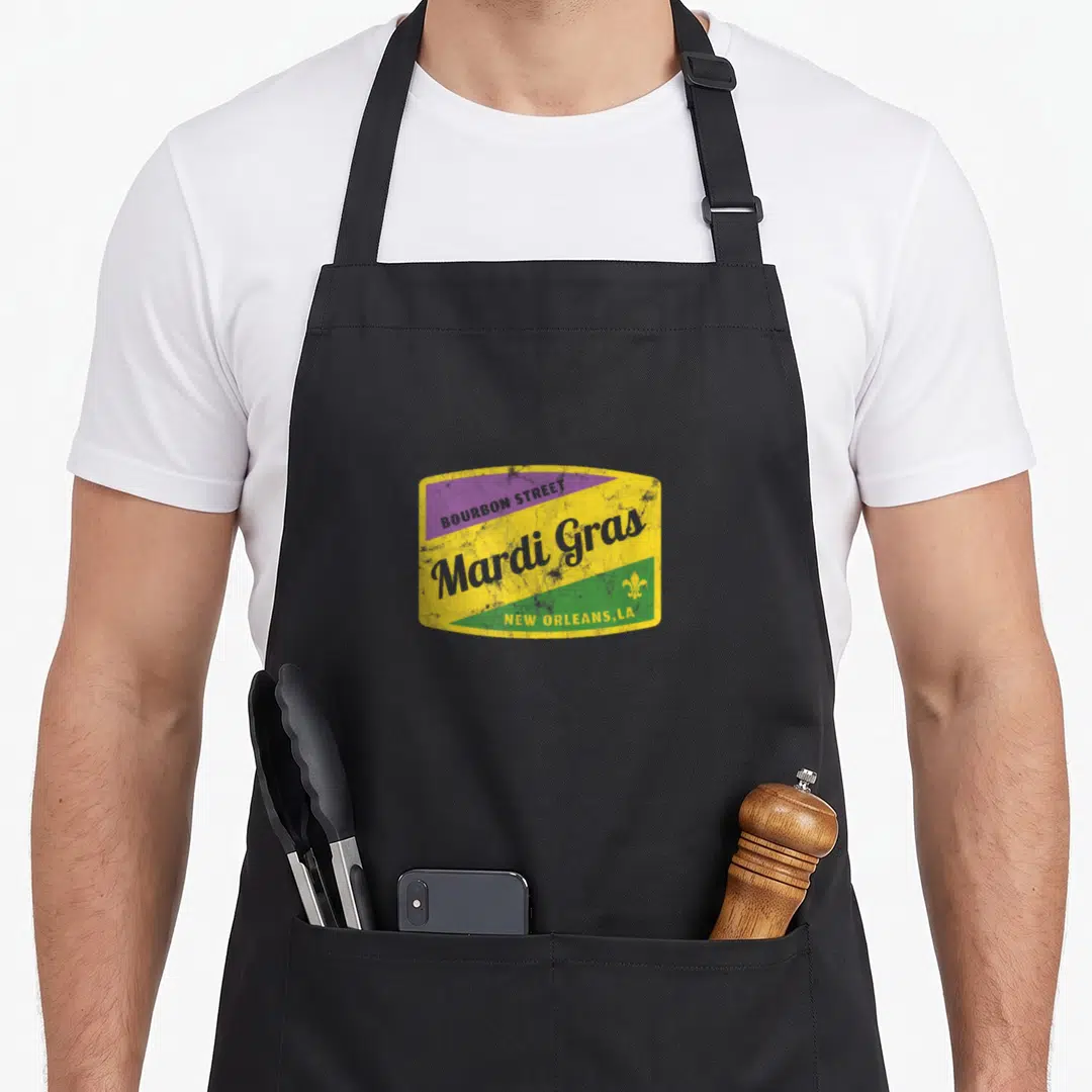 Bourbon mardi gras aprons - Retro sign with BOURBON STREET text and yellow purple green bands — shown on a black cotton canvas apron against a white background