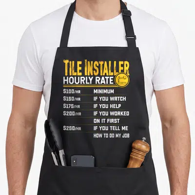 Tile contractors apron - Yellow and white text listing tile installer hourly rates from 100 to 250 dollars — shown on a black cotton canvas apron against a white background