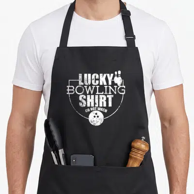 Lucky bowling apron - White distressed text Lucky Bowling Shirt Do Not Wash with pins and ball graphic — shown on a black cotton canvas apron against a white background