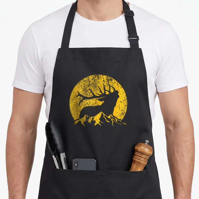 Elk hunter bow apron - Grey elk silhouette standing on mountains against a distressed yellow sun circle — shown on a black cotton canvas apron against a white background