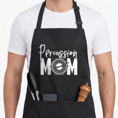 Percussion mother's apron - White script reading Percussion above block letters MOM containing a drum graphic — shown on a black cotton canvas apron against a white background