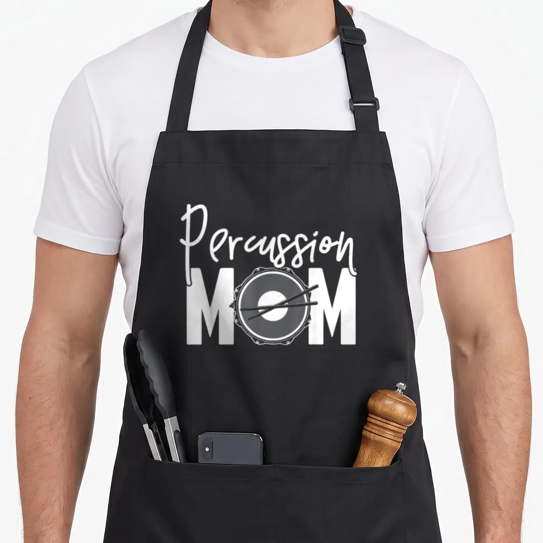 Percussion mother's apron - White script reading Percussion above block letters MOM containing a drum graphic — shown on a black cotton canvas apron against a white background