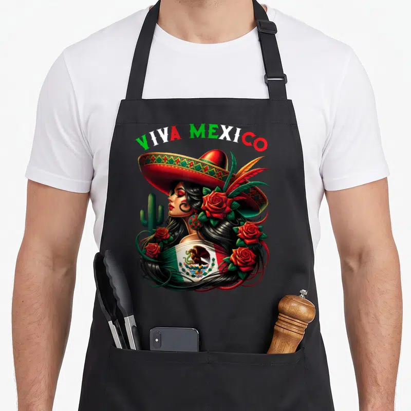 Flag pride mexico apron - Viva Mexico text above woman sombrero Mexican flag red roses cactus realistic art — shown on a black cotton canvas apron against a white background