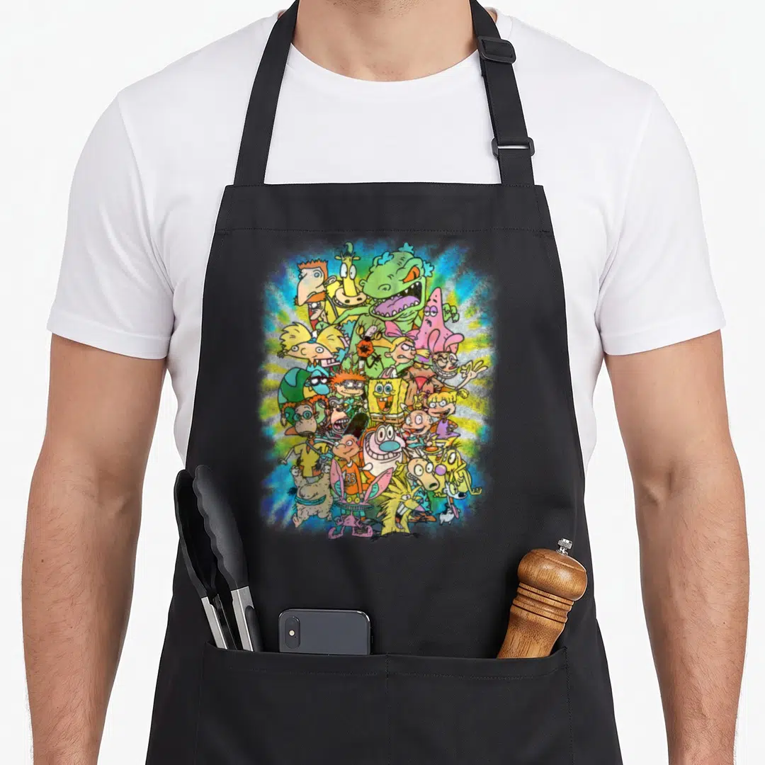 Nick ultimate apron - Overlapping cartoon characters on blue yellow green pink radial burst background — shown on a black cotton canvas apron against a white background