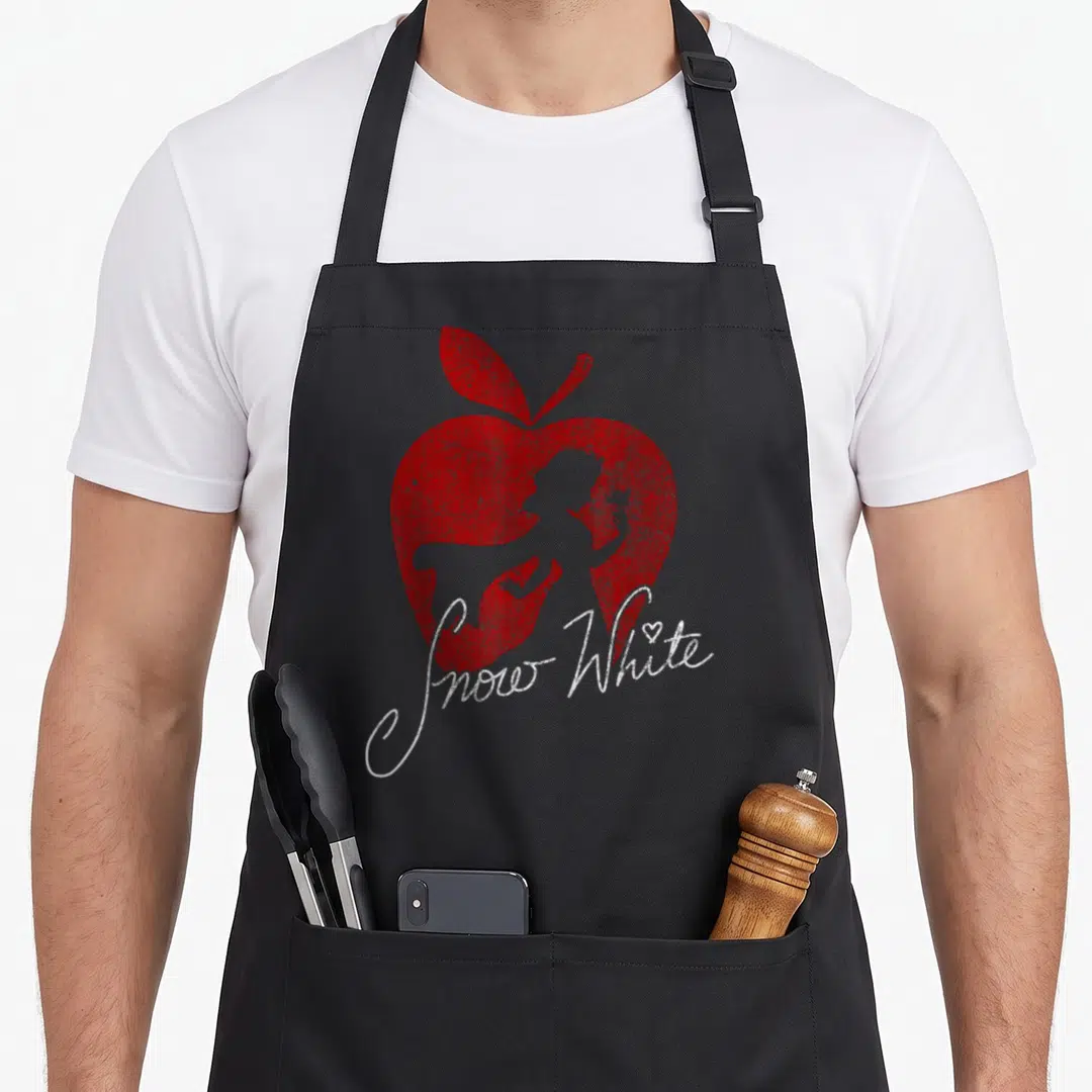 Silhouette apple apron - Red apple silhouette with grey figure inside and white Snow White text — shown on a black cotton canvas apron against a white background