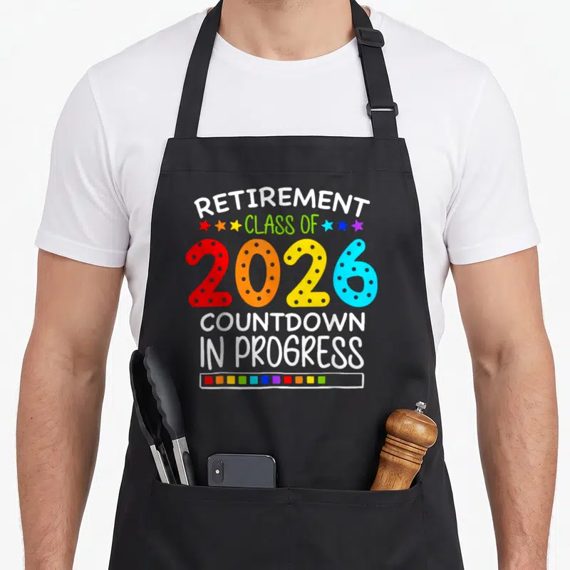 Retirement class teacher apron - Colorful 2026 marquee number with retirement countdown text and progress bar — shown on a black cotton canvas apron against a white background