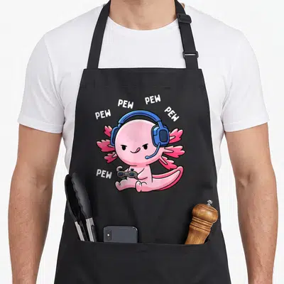 Pew video game apron - Pink axolotl with blue headphones holding grey controller surrounded by white PEW text — shown on a black cotton canvas apron against a white background