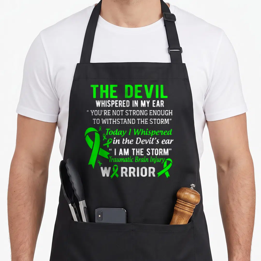Storm tbi awareness apron - Green and white stacked text with one large and four small TBI awareness ribbons — shown on a black cotton canvas apron against a white background