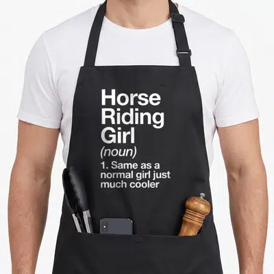 Sassy horse apron - White stacked text defining Horse Riding Girl as same as normal girl but cooler — shown on a black cotton canvas apron against a white background