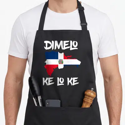 Manin pride apron - Map of Dominican Republic filled with flag colors and white text Dimelo Ke Lo Ke — shown on a black cotton canvas apron against a white background
