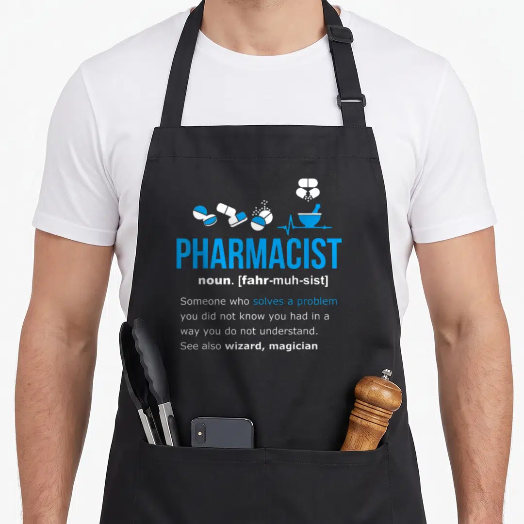 Definition pharmacist apron - Blue and white PHARMACIST dictionary definition with scattered pill and mortar icons — shown on a black cotton canvas apron against a white background