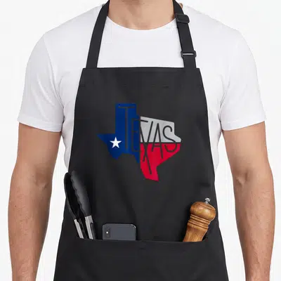 Beautiful texas apron - Texas state map filled with blue white and red colors with grey TEXAS text and white star — shown on a black cotton canvas apron against a white background