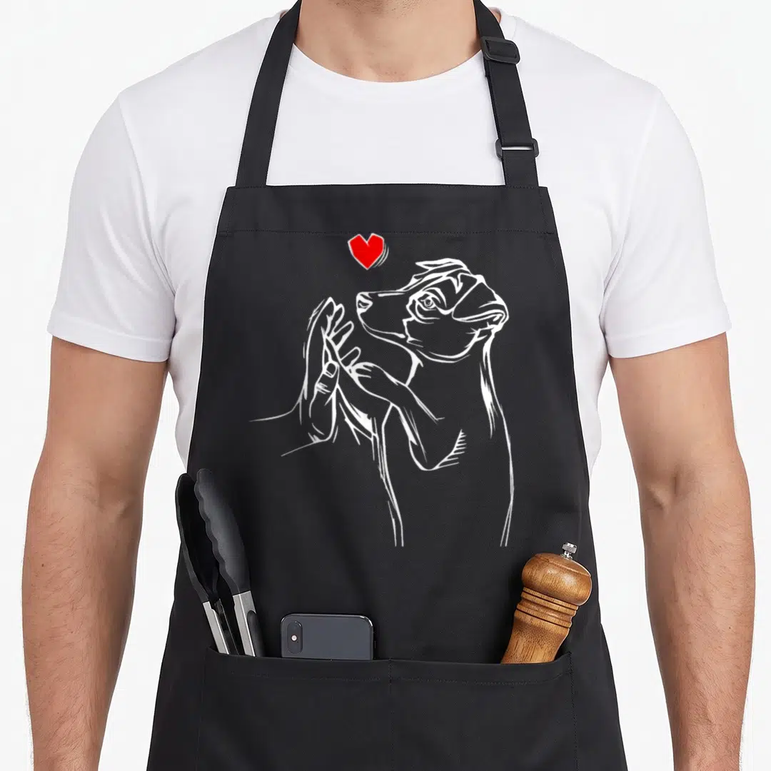 Russell dog dad apron - White line-art terrier being petted by a hand with a red heart floating above — shown on a black cotton canvas apron against a white background