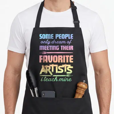 Teach painter apron - Stacked rainbow text with two horizontal paintbrushes and inspirational quote — shown on a black cotton canvas apron against a white background