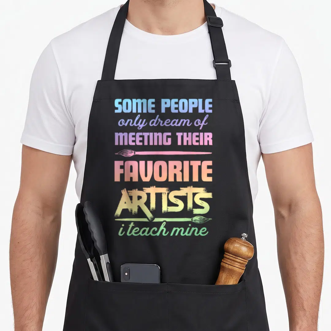 Teach painter apron - Stacked rainbow text with two horizontal paintbrushes and inspirational quote — shown on a black cotton canvas apron against a white background