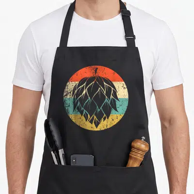 Hop craft apron - Grey hop cone over red cream teal and yellow horizontal stripes in retro art style — shown on a black cotton canvas apron against a white background