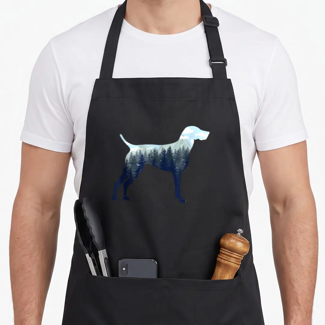Nature pointer apron - Dog silhouette filled with blue pine forest, mountains, and white clouds — shown on a black cotton canvas apron against a white background