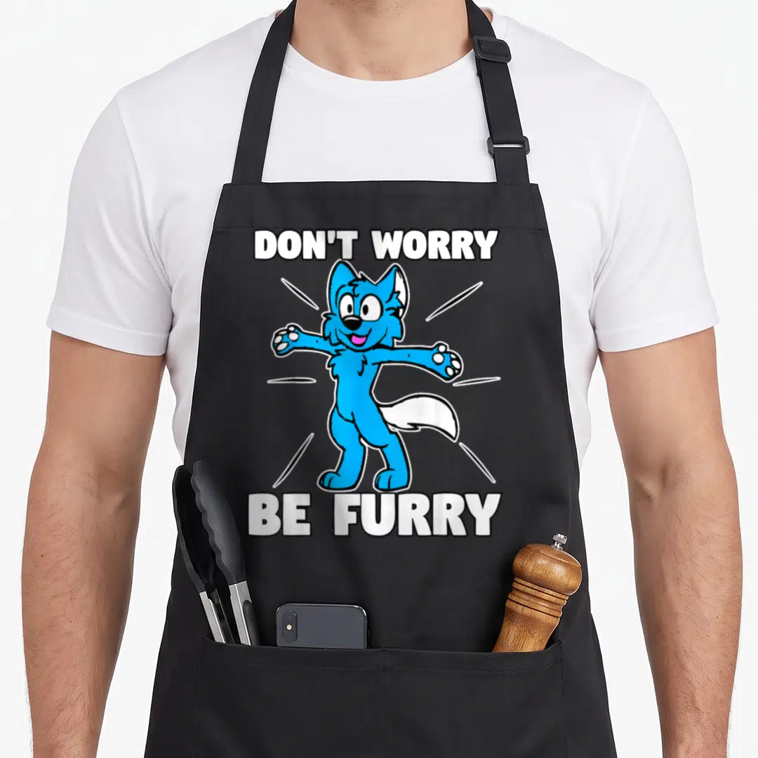 Furry fox aprons - Blue cartoon wolf character between white text DON'T WORRY BE FURRY with radiating lines — shown on a black cotton canvas apron against a white background