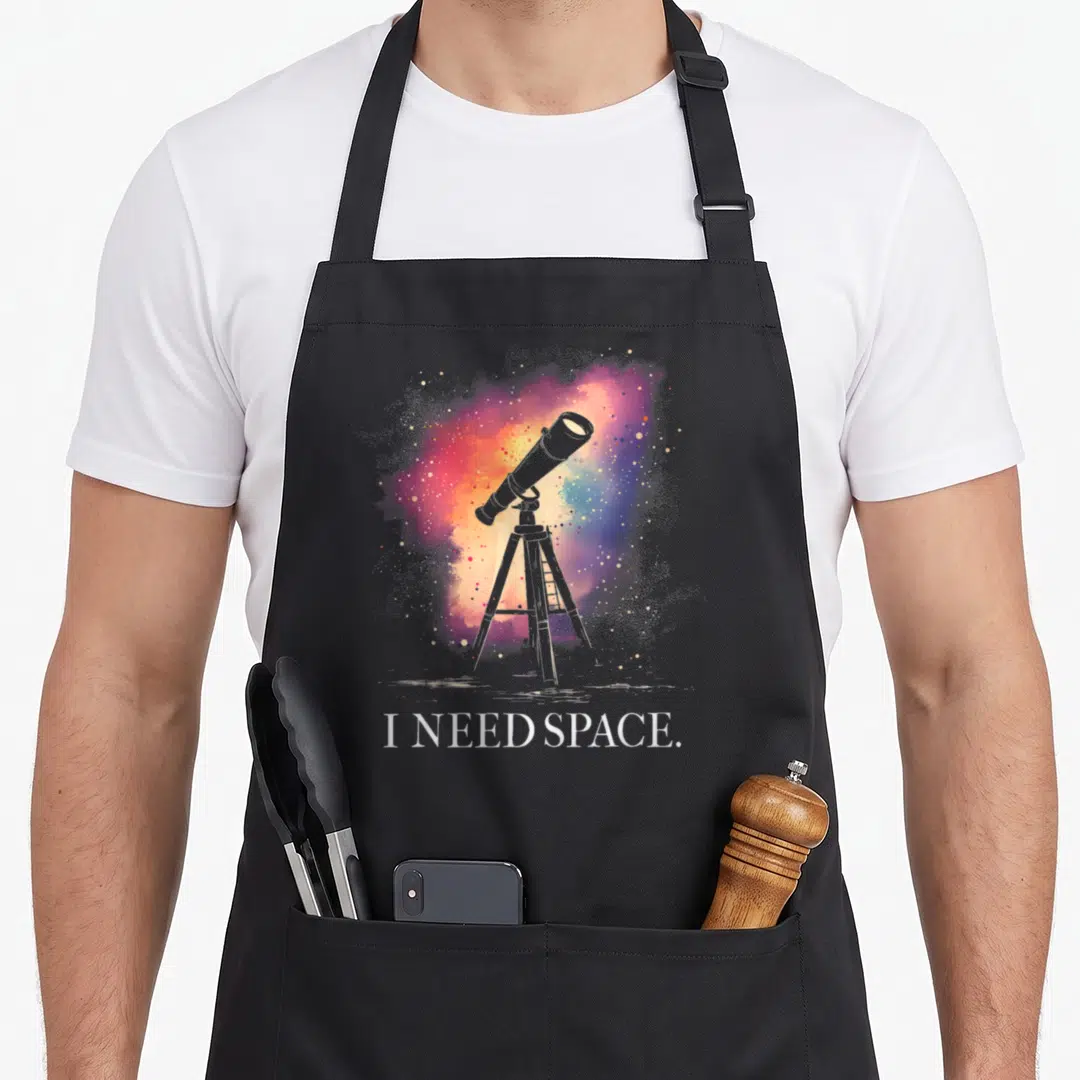 Astronomy astronomer apron - Grey telescope on tripod against purple pink orange blue white watercolor nebula — shown on a black cotton canvas apron against a white background